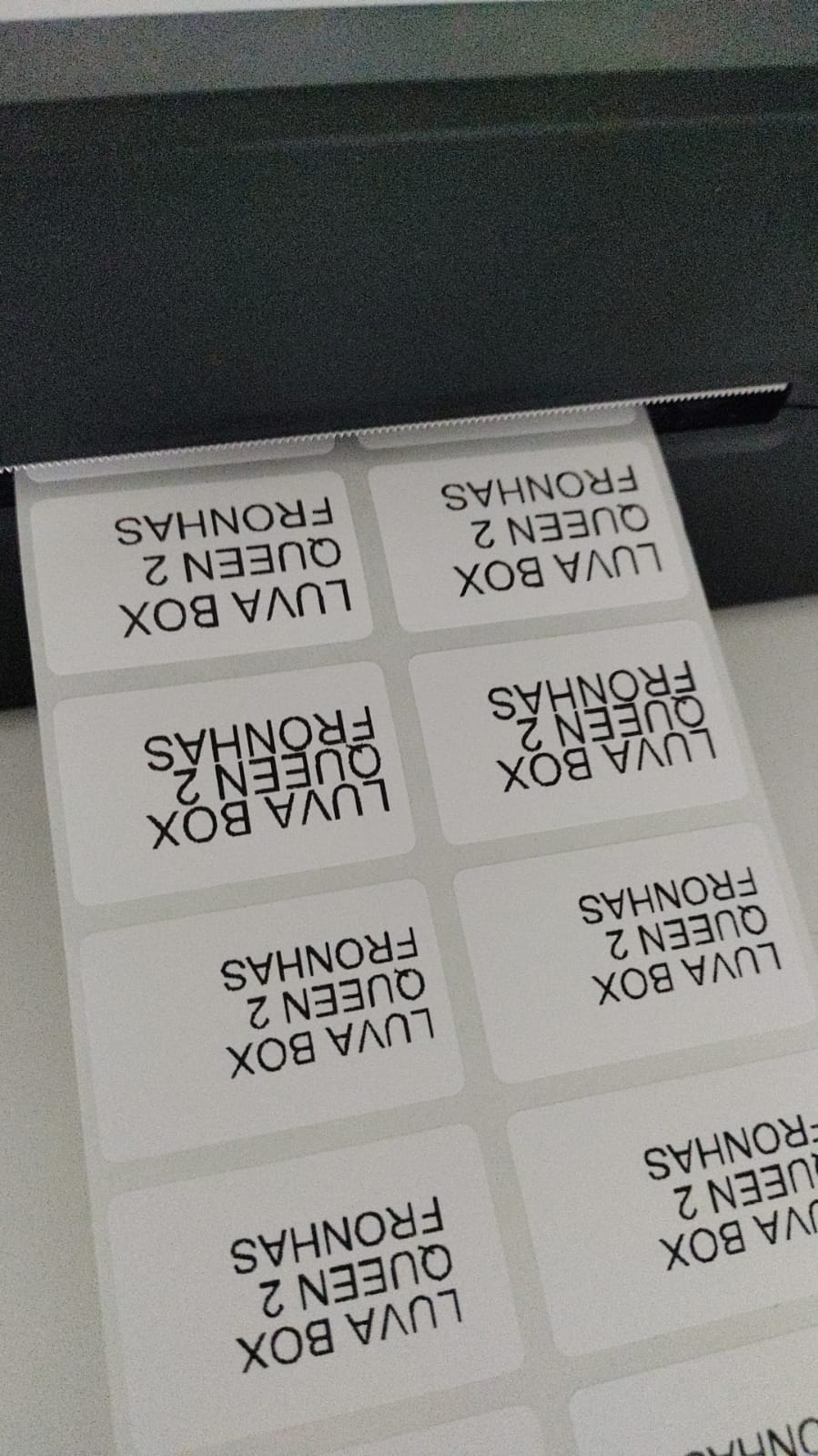 Etiquetas do cliente de enxovais saindo da impressora térmica no formato novo