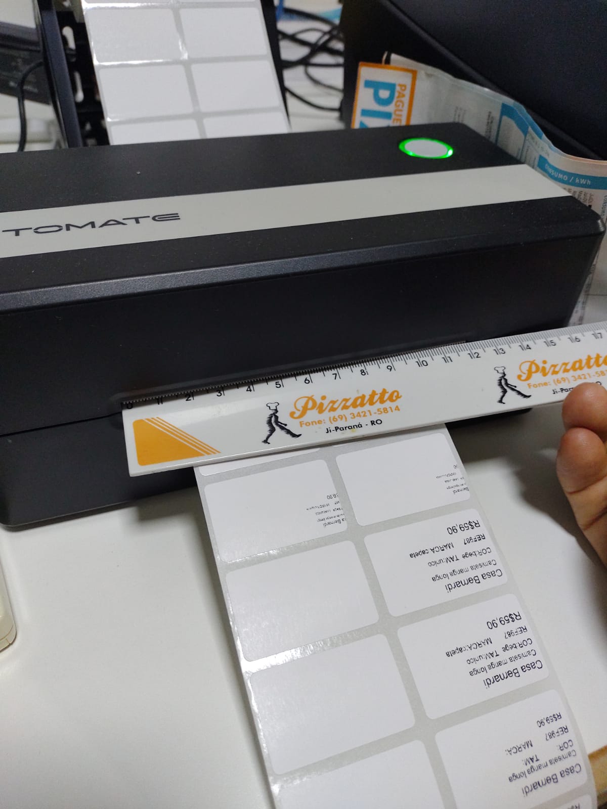 Régua de plástico medindo etiquetas na saída da impressora térmica Tomate 007